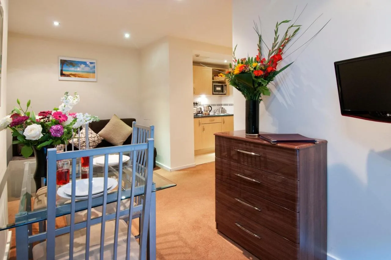 a living room with a crib and flowers on a dresser at Grand Plaza Serviced Apartments in London