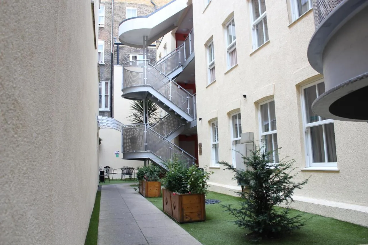 a courtyard with plants and stairs in a building at Grand Plaza Serviced Apartments in London