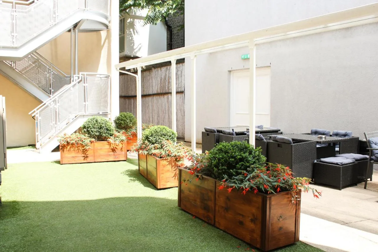 a courtyard with several plotted plants in wooden boxes at Grand Plaza Serviced Apartments in London