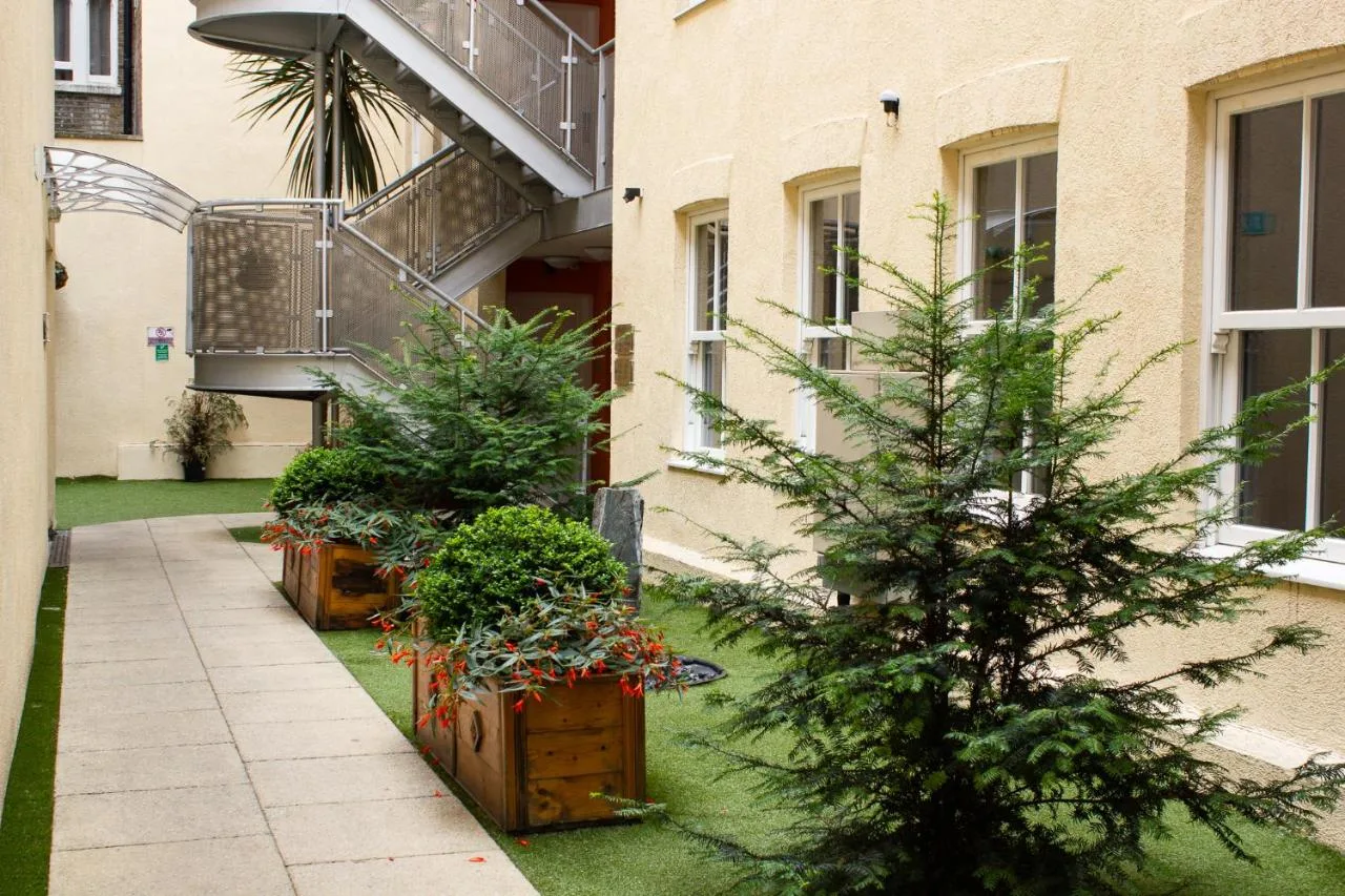 a courtyard with potted plants in front of a building at Grand Plaza Serviced Apartments in London